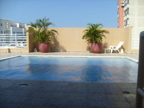 a swimming pool with palm trees and a building at Edificio Torre Centauro in Cartagena de Indias