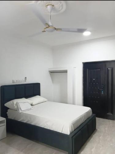 ein Schlafzimmer mit einem Bett mit blauem Kopfteil in der Unterkunft Meg place in Amamoli