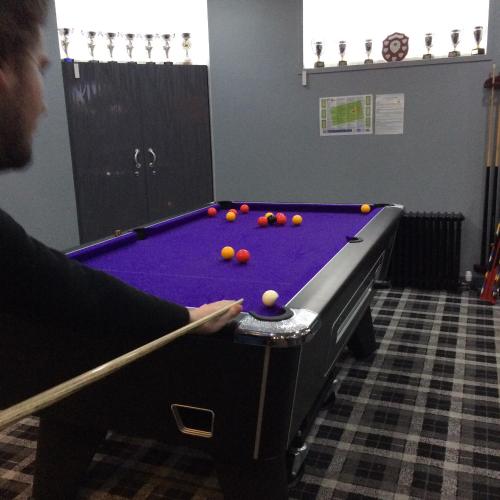 a man playing a game of pool in a room at The Davron Hotel in Fraserburgh
