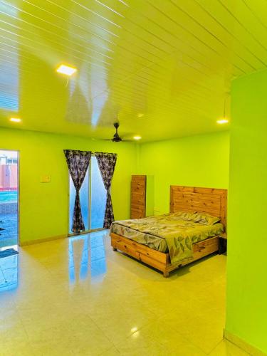 ein Schlafzimmer mit einem Bett in einem Zimmer mit grünen Wänden in der Unterkunft empire villa in Malavli