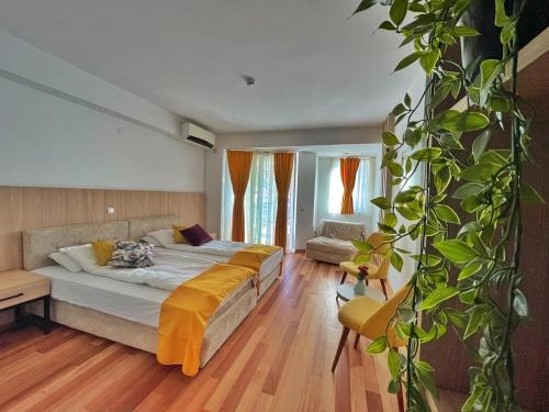 ein Schlafzimmer mit einem Bett und einer Pflanze in der Unterkunft Villa Nika Pestani in Peštani