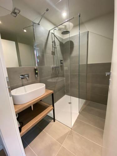 a bathroom with a sink and a glass shower at Malvezzi24 Boutique Rooms in Desenzano del Garda
