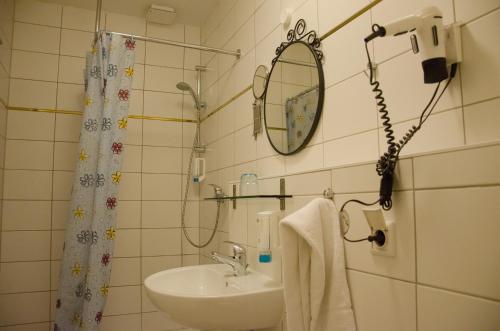 a bathroom with a sink and a mirror at Panorama Hotel Frankfurt Offenbach Süd in Offenbach