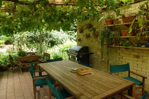 a wooden table and chairs with a grill on a patio at Waitomo Caves Guest Lodge in Waitomo Caves
