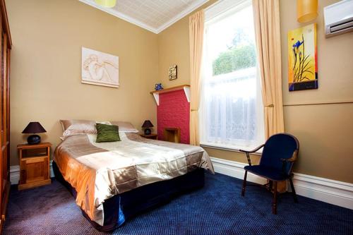 um quarto com uma cama, uma cadeira e uma janela em Ugbrooke Country Estate em Lower Dashwood