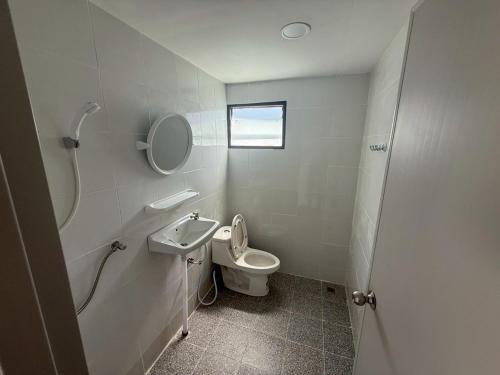 a white bathroom with a toilet and a sink at ต้นตาล&ตาลฟ้า รีสอร์ท in Ban Nong Khang