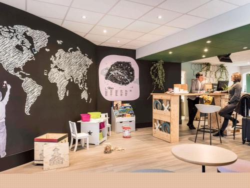 a room with a map of the world on a wall at Aparthotel Adagio Paris Montmartre in Paris