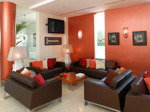 a living room with two couches and a tv at Hotel Praia Sol in Quarteira