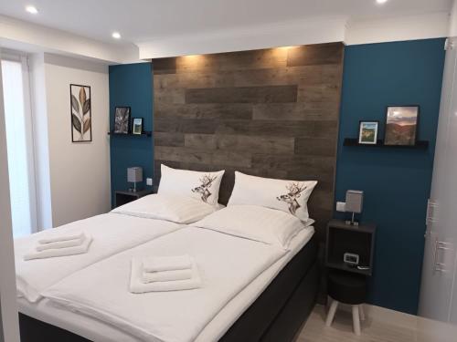 een groot bed in een kamer met een blauwe muur bij Ferienwohnung Feel Glueck in Bad Grund