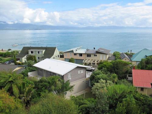 een groep huizen met de oceaan op de achtergrond bij Sea View Batch in Takaka