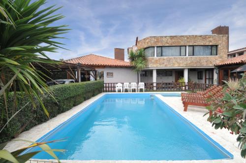 - une piscine en face d'une maison dans l'établissement Madeo Hotel & Spa, à Villa Carlos Paz