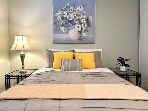 a bedroom with a bed with yellow pillows and a painting at Cozy One-Bedroom Haven with Big Balcony in Vancouver