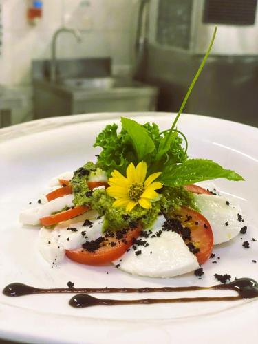 une assiette de nourriture avec des légumes et une fleur jaune dessus dans l'établissement Sea Turtles Bungalow, à Bentota