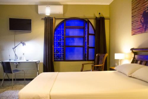 a bedroom with a bed and a window at La Guaca Hostel Santa Marta in Santa Marta