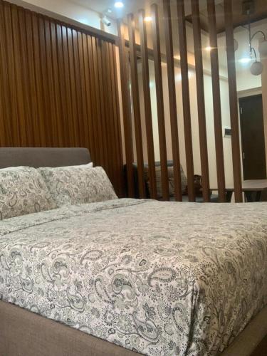 een slaapkamer met een bed met een witte deken bij Centrio Tower New Condo unit 2 in Cagayan de Oro