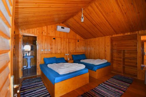 two beds in a room with wooden walls at Magic land taba camp in Taba