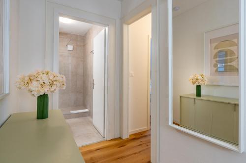 een hal met een vaas met bloemen op een tafel bij Vertical Suite Modern 3 Bedroom Apartment near Central Station in Zürich