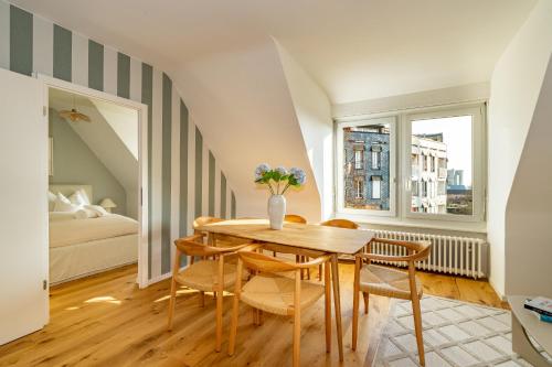een eetkamer met een tafel en stoelen en een bed bij Vertical Suite Modern 3 Bedroom Apartment near Central Station in Zürich