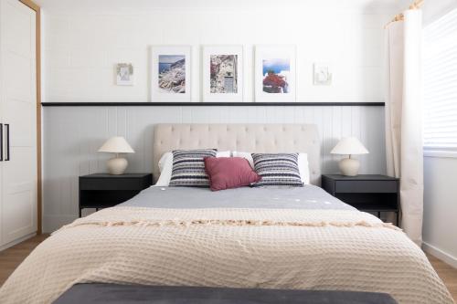 een slaapkamer met een groot bed met twee nachtkastjes bij Whitsunday Wanderluxe in Cannonvale