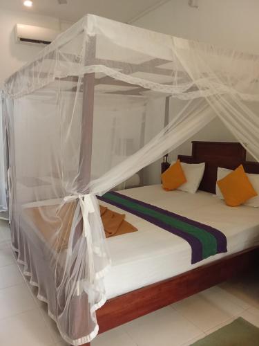 a bed with a canopy in a room at New Hotel Bundala park in Tissamaharama