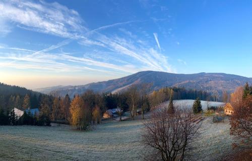 a view of a field with a mountain in the background at Penzion Soukupovi in Strážné