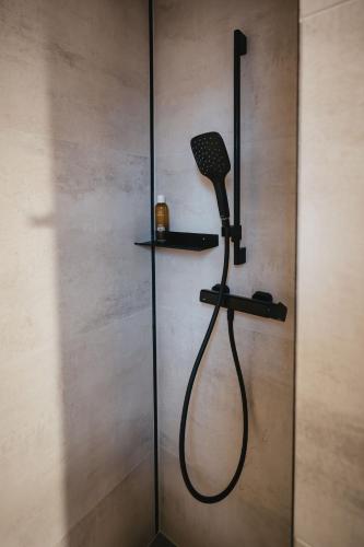 a shower with a blow dryer on a wall at Nature Nest Noszvaj in Noszvaj