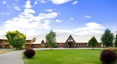 ein großes Gebäude mit grünem Rasen davor in der Unterkunft Discovery Countrytime Hotel Omarama in Omarama