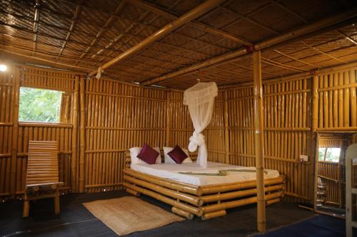 a bedroom with a bed in a bamboo room at Dodo's Bamboo Resort in Rāja Māyang
