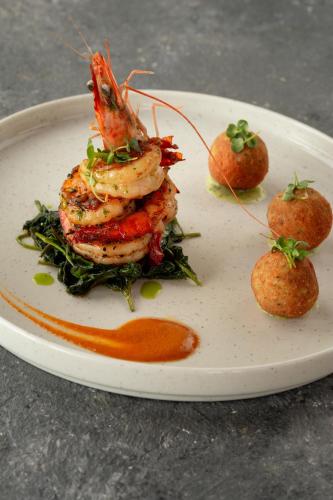 a plate of food with shrimp and vegetables on it at Oruva Beachside Villa in Galle