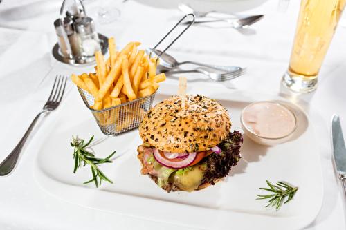 a white plate with a sandwich and french fries at Urdlwirt - Hotel & Restaurant in Premstätten