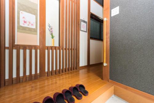 een rij schoenen op de vloer van een gang bij Guesthouse Nobi in Kyoto