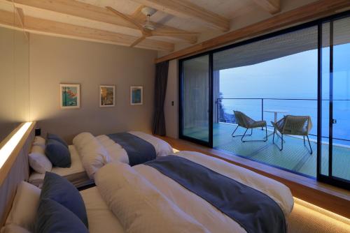 a bedroom with two beds and a balcony at KONA RESORT AWAJI KAI in Awaji