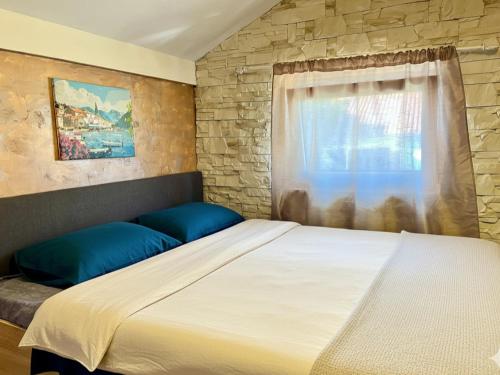 a bedroom with a large bed and a window at Apartments Obradovic in Krašići