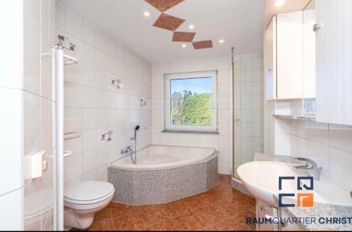 um banheiro com banheira, vaso sanitário e pia em MPK Motorsport Apartment em Waldsassen