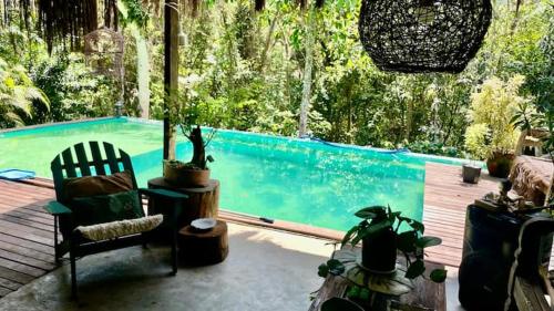 een kamer met een zwembad en een ligstoel bij SAVAGE - pousada 
