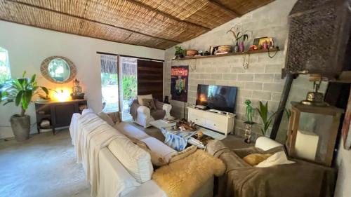 een woonkamer met witte banken en een tv bij SAVAGE - pousada 