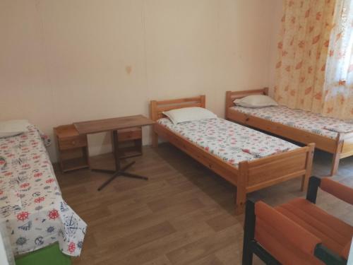 a small room with two beds and a table at Бунгала Дъбрава in Shkorpilovtsi