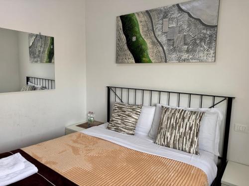 een slaapkamer met een bed en een schilderij aan de muur bij Confortini Rooms SUNDAY in Verona