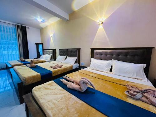 three beds in a hotel room with towels on them at Ayos Hill Adam's Peak Free Shuttle in Nallathanniya