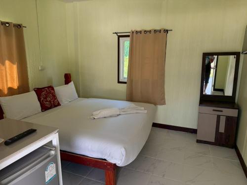 a bedroom with a large bed and a television at ต้นตาล&ตาลฟ้า รีสอร์ท in Ban Nong Khang