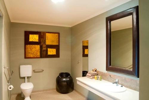 a bathroom with a sink and a toilet and a mirror at Bairnsdale Motel in Bairnsdale