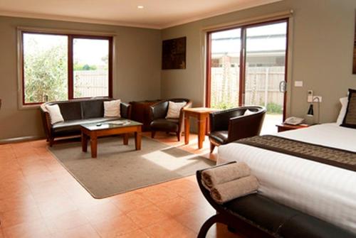 a bedroom with a bed and a living room at Bairnsdale Motel in Bairnsdale