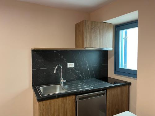 una cucina con un lavello e un piano di lavoro di Aleminas Rooms 2 a Sými