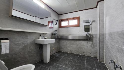 een badkamer met een wastafel en een toilet bij welcalm village in Naemulch'i-ri