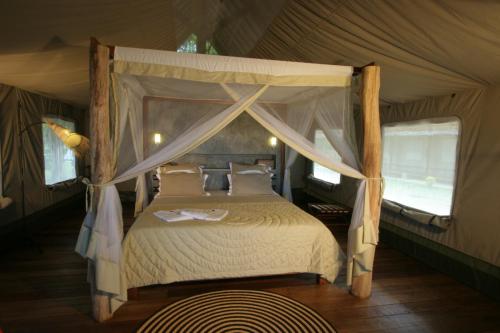 a bedroom with a canopy bed in a tent at Eden Lodge in Madirokely