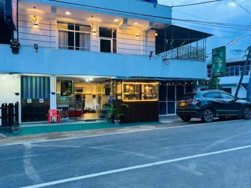 ein Auto, das vor einem Gebäude in einer Straße geparkt ist in der Unterkunft Ayos Hill Adam's Peak Free Shuttle in Nallathanniya