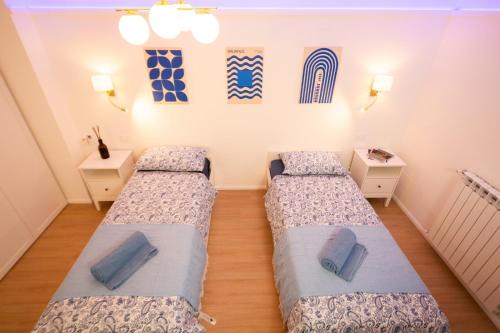 Habitación con 2 camas y 2 mesitas de noche en Infinity Blue - Sunny Coastal Apartment, en Ospedaletti