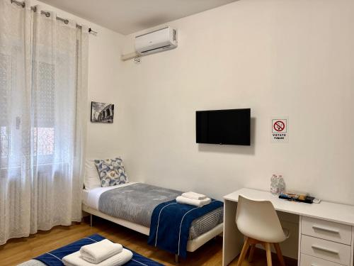 een slaapkamer met een bed en een bureau met een computer bij Nuovo Confortini Rooms SUNDAY in Verona