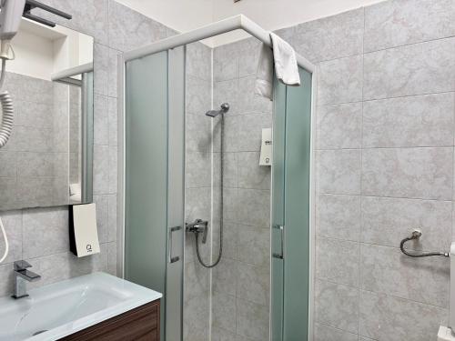 een badkamer met een douche met wastafel en spiegel bij Nuovo Confortini Rooms SUNDAY in Verona