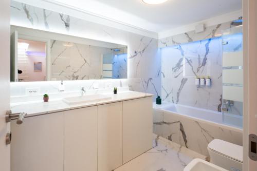 Un baño con lavabo, bañera e inodoro. en Infinity Blue - Sunny Coastal Apartment, en Ospedaletti